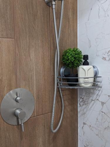 a metal shelf on a wall with a shower at Studio Apartment City Dream in Stara Zagora