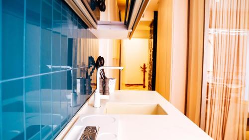 a bathroom with a white sink and a blue wall at DON ANDREA in Taormina