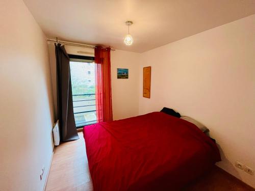 - une chambre avec un lit rouge et une fenêtre dans l'établissement Casa Jamin - Metro - Wifi - Parking - Dream Host, à Saint-Denis