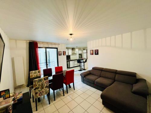 un salon avec un canapé, une table et des chaises dans l'établissement Casa Jamin - Metro - Wifi - Parking - Dream Host, à Saint-Denis