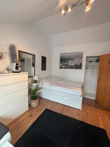 a bedroom with a bed and a dresser at Privatunterkunft Am Aaper Wald in Düsseldorf