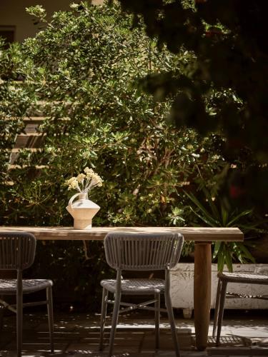 a table with two chairs and a vase on it at Shellona Rooms & Apartments in Laganas