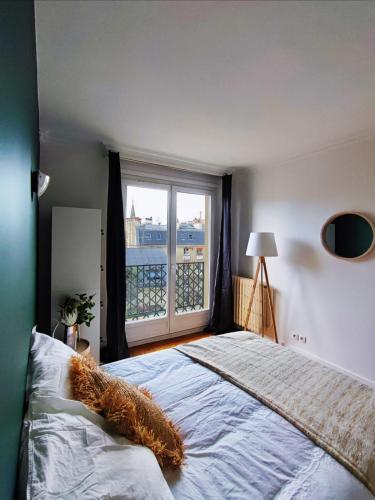 une chambre avec un grand lit avec une grande fenêtre dans l'établissement Flexliving - room - Villon, à Paris