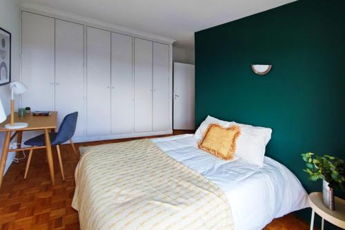une chambre avec un grand lit avec un mur végétal dans l'établissement Flexliving - room - Villon, à Paris