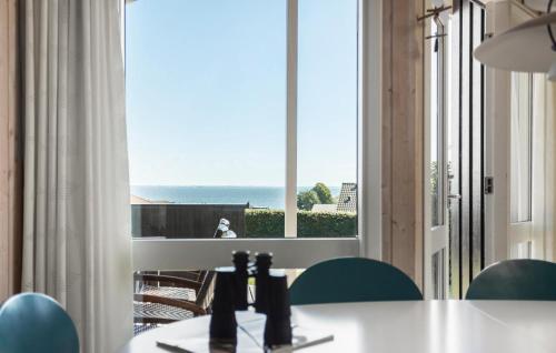 a room with a table and a view of the ocean at Nice Home In Sjølund With Sauna in Sjølund