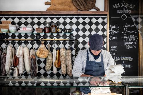 a man is standing behind a counter in a bakery at Luxury Residences by Widder Hotel in Zürich