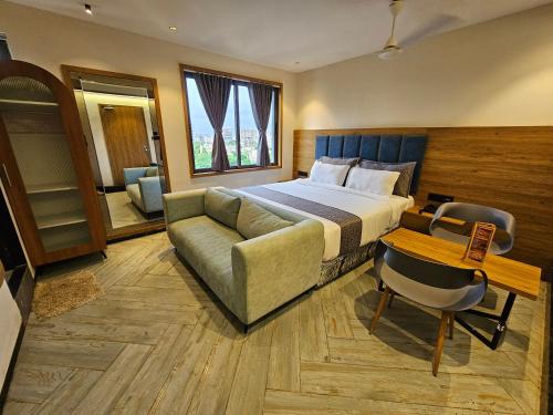 a hotel room with a bed and a couch at Nova Park in Rajkot