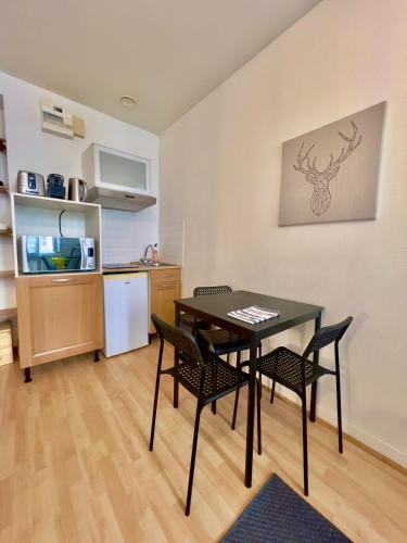une cuisine et une salle à manger avec une table et des chaises dans l'établissement Le Châteaudun Thabor Centre ville, à Rennes
