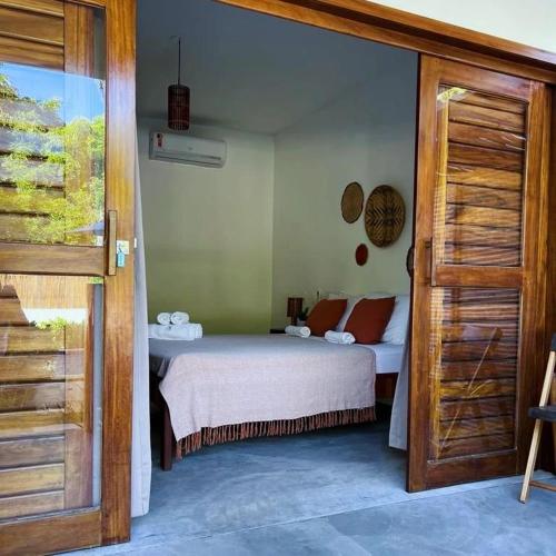 a bedroom with a bed and a door open at POUSADA VILLA SOLEIL icaraizinho in Icaraí
