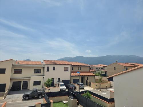 Vue aride d'un parking avec bâtiments dans l'établissement Maison pour 6p - 3ch - piscine privée - au calme, à Argelès-sur-Mer