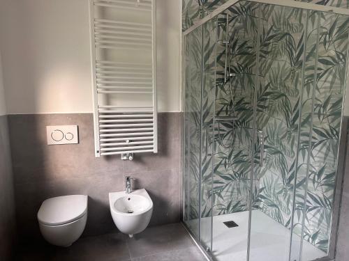 a bathroom with a toilet and a sink and a shower at Appartamenti Ai 7 nani in Peron