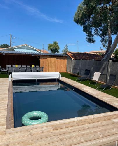- une piscine avec une façade en face d'une maison dans l'établissement Villa bassin d’Arcachon Notre Hutte, à Gujan-Mestras