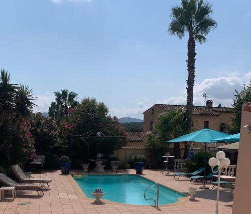 - une piscine avec un palmier, une table et des chaises dans l'établissement Villa Provençale climatisée avec jardin, piscine, barbecue, sauna, à Mougins