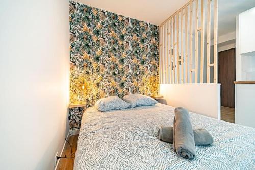 une chambre avec un lit avec un mur d'accent floral dans l'établissement 