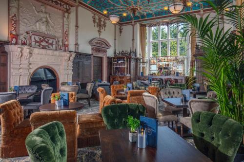 クルーにあるCrewe Hall Hotel & Spa - Cheshireのテーブルと椅子と暖炉のあるレストラン