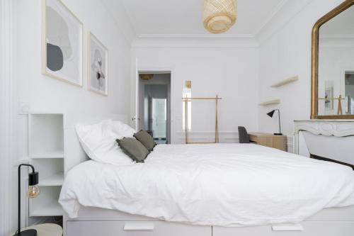 une chambre blanche avec un grand lit blanc dans l'établissement Flexliving - room - Caulaincourt, à Paris