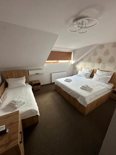 a hotel room with two beds and a window at Hotel Imperium & Pool in Caracal