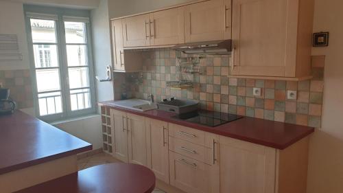 une cuisine avec des armoires en bois et un évier dans l'établissement T3 Centre, à Romans-sur-Isère