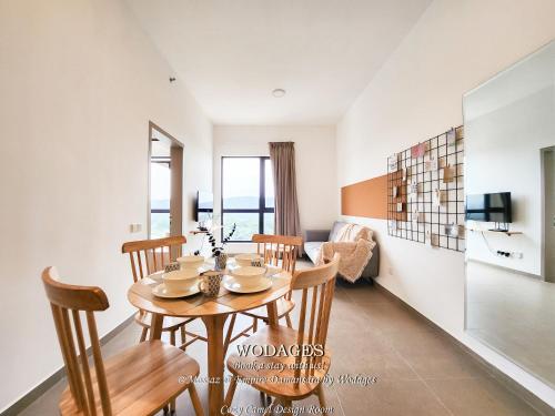 a dining room and living room with a table and chairs at Mossaz at Empire Damansara by Wodages in Kuala Selangor