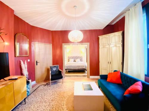 - un salon avec un canapé bleu et un lit dans l'établissement La suite 2 pièces lit queen size entrée privée, à Nîmes