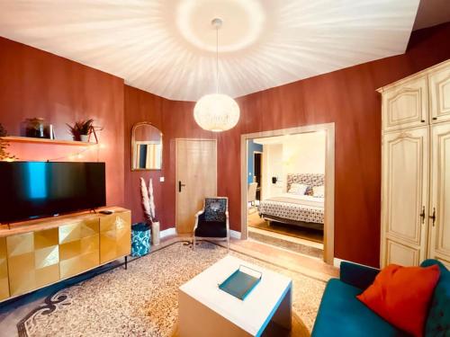 un salon avec un canapé et une télévision dans l'établissement La suite 2 pièces lit queen size entrée privée, à Nîmes