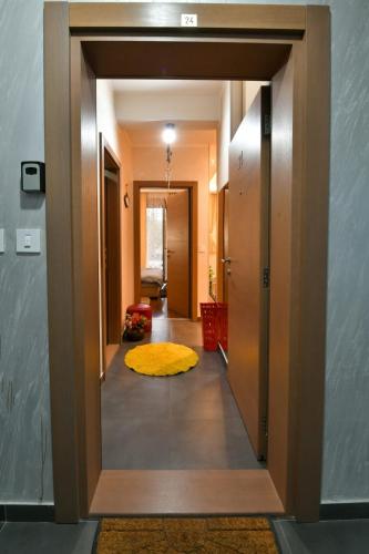 a hallway with a door open to a room with a yellow rug at Lux apartman Popovic in Zlatibor