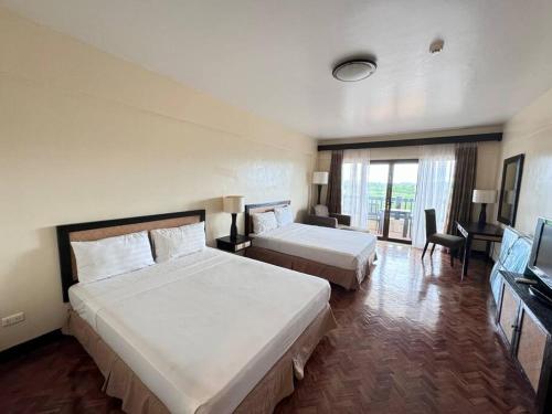 a hotel room with two beds and a television at K106 Alta Vista De Boracay in Boracay