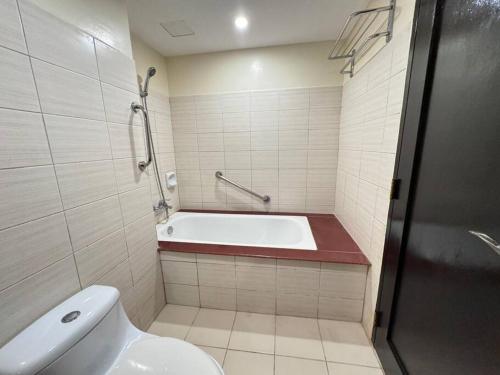 a bathroom with a bath tub and a toilet at K106 Alta Vista De Boracay in Boracay