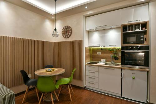 a kitchen with a table and some green chairs at Lux apartman Popovic in Zlatibor