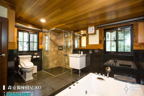 a bathroom with a tub and a toilet and a shower at 日月潭森堡萊夫莊園 in Yuchi