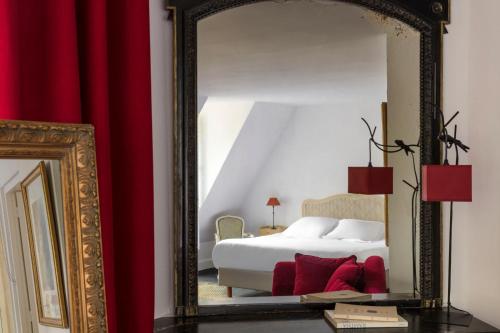 a bedroom with a bed and a mirror at Hostellerie Du Château Les Muids in La Ferté-Saint-Aubin