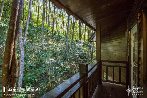 a porch of a cabin with a view of a forest at 日月潭森堡萊夫莊園 in Yuchi