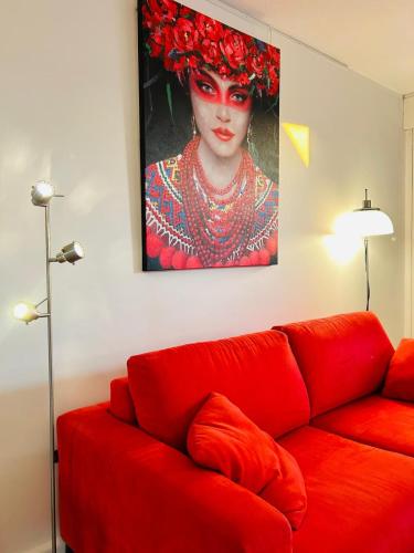 - un canapé rouge dans le salon orné d'une peinture murale dans l'établissement Studio RED MASTER, à Saint-Tropez