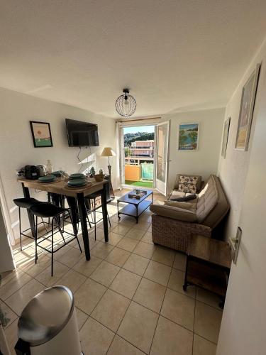 un salon avec une table et un canapé dans l'établissement T2 cabine tout équipé, 300m mer, à Bormes-les-Mimosas