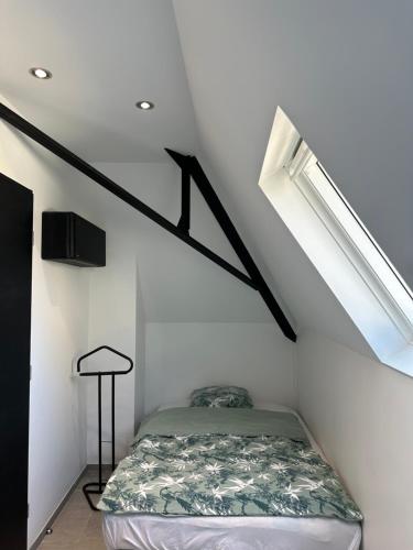 a bedroom with a bed in a white room at Le Victor Hugo - SPA in Nevers