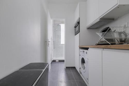 - une cuisine blanche avec lave-linge et sèche-linge dans l'établissement Flexliving - room - Caulaincourt, à Paris