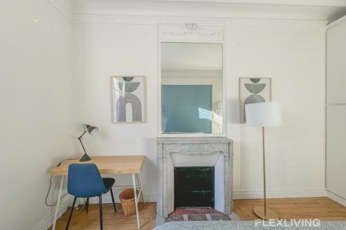une pièce avec un bureau et une cheminée avec un miroir dans l'établissement Flexliving - room - Felix Faure, à Paris