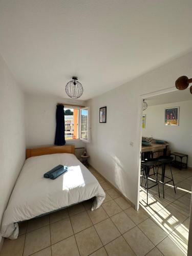 une chambre avec un lit, une table et une fenêtre dans l'établissement T2 cabine tout équipé, 300m mer, à Bormes-les-Mimosas