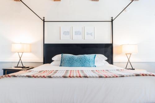 a bed with a black headboard and two lamps at Mercury Hotel Provincetown in Provincetown