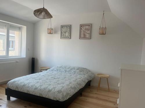 - une chambre avec un lit et trois photos sur le mur dans l'établissement Maison de pêcheur à Rosendaël, à Dunkerque