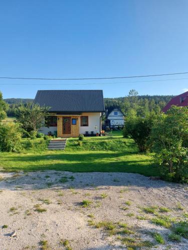 a small house with a black roof on a yard at Wypoczynkowy Zakątek w Górach in Stronie Śląskie