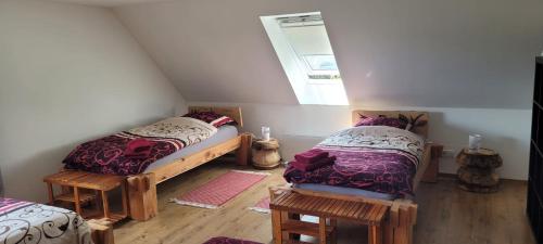a attic room with two beds and a window at HarzRitter Domizil in Cattenstedt