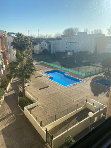 - une vue aérienne sur la piscine dans un parking dans l'établissement Capfamille, au Cap d'Agde