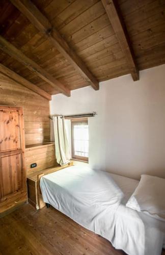 a bedroom with a bed in a room with a window at Abissinia, Gioiello nel Bosco in Poiano
