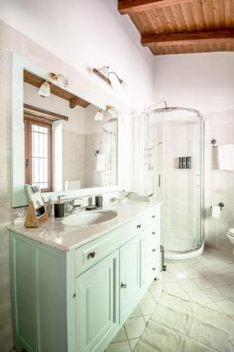 a white bathroom with a sink and a shower at Abissinia, Gioiello nel Bosco in Poiano