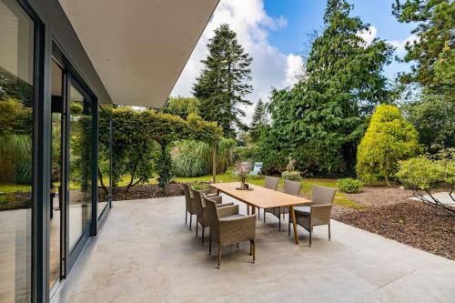 a patio with a wooden table and chairs at Haus Lavard in Leck