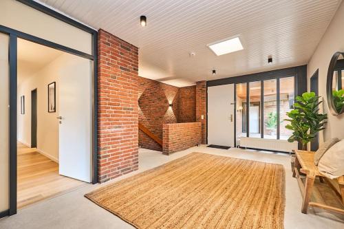 a living room with a brick wall and a rug at Haus Lavard in Leck