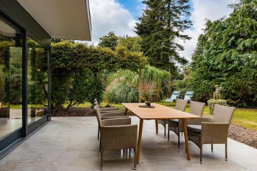 a patio with a wooden table and chairs at Haus Lavard in Leck