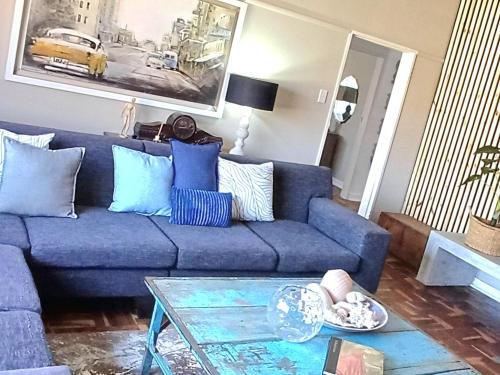 a blue couch in a living room with a table at Kruger Huisie Parys in Parys