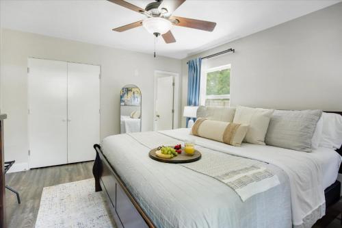 a bedroom with a bed with a tray of fruit on it at The Canopy on 10th - Game Room , Pets , Pergola in Gainesville